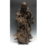 A large Chinese rootwood figure, carved as an elder holding a ripe peach and a staff, 70cm high,
