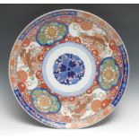 A large Japanese Imari porcelain circular charger, the elaborate border painted in the typical