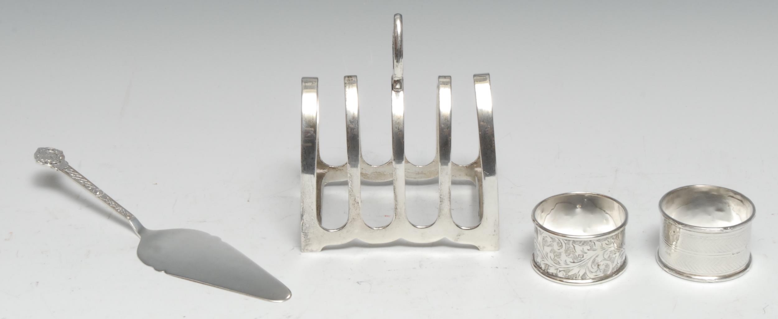 A George V silver five bar toast rack, axehead handle, pointed arched divisions, 9.5cm long, E