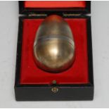 Stuart Devlin (1931 - 2018) - an Elizabeth II silver-gilt and silver surprise egg, enclosing a