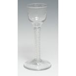 An English cordial glass, bucket shaped bowl engraved with scrolling vine, cotton twist stem