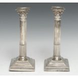 A pair of Victorian silver stop-fluted Corinthian column table candlesticks, detachable nozzles,