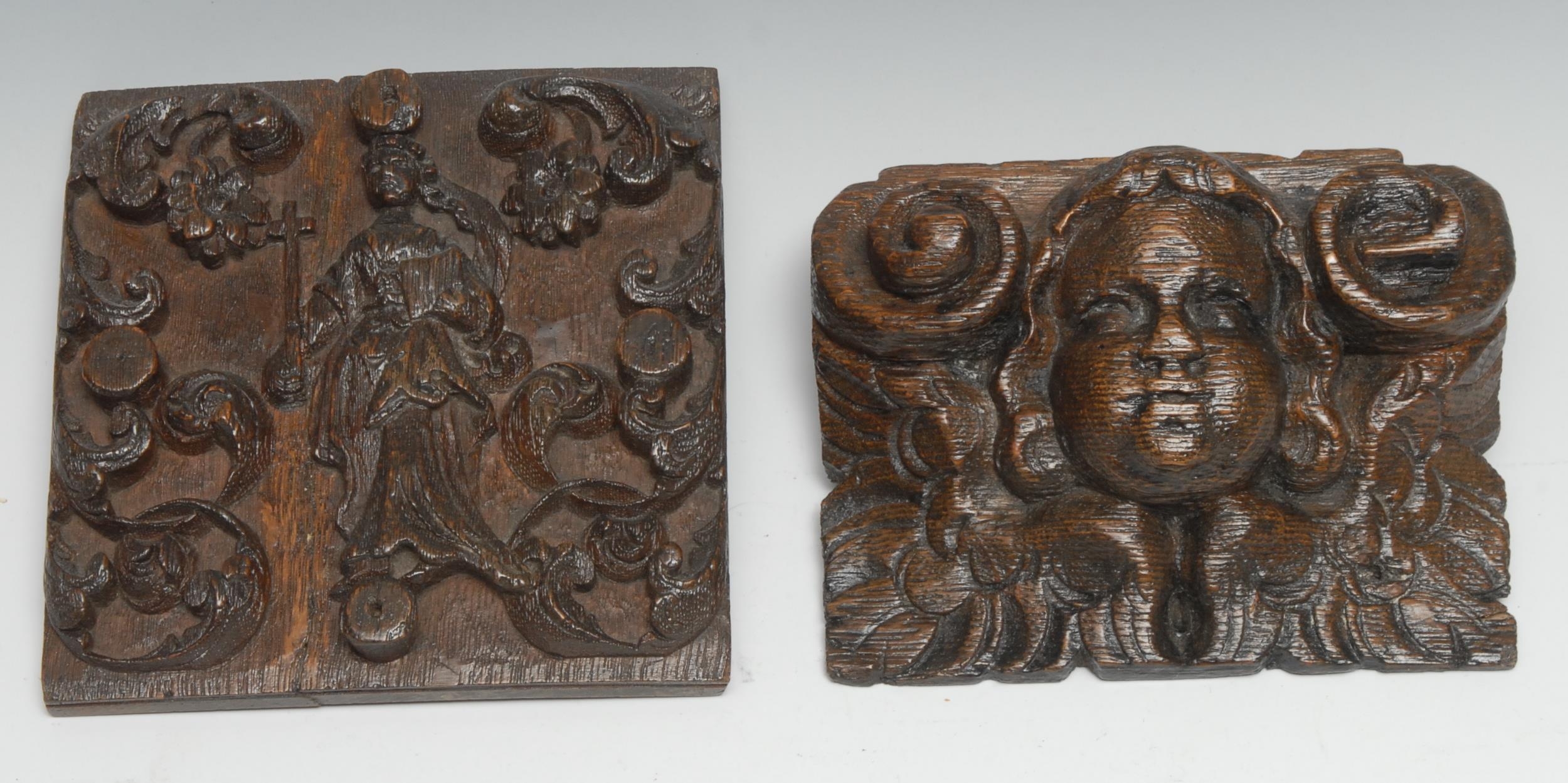 A 17th century oak panel, carved in relief with St Helena and attributes, flanked by flowering