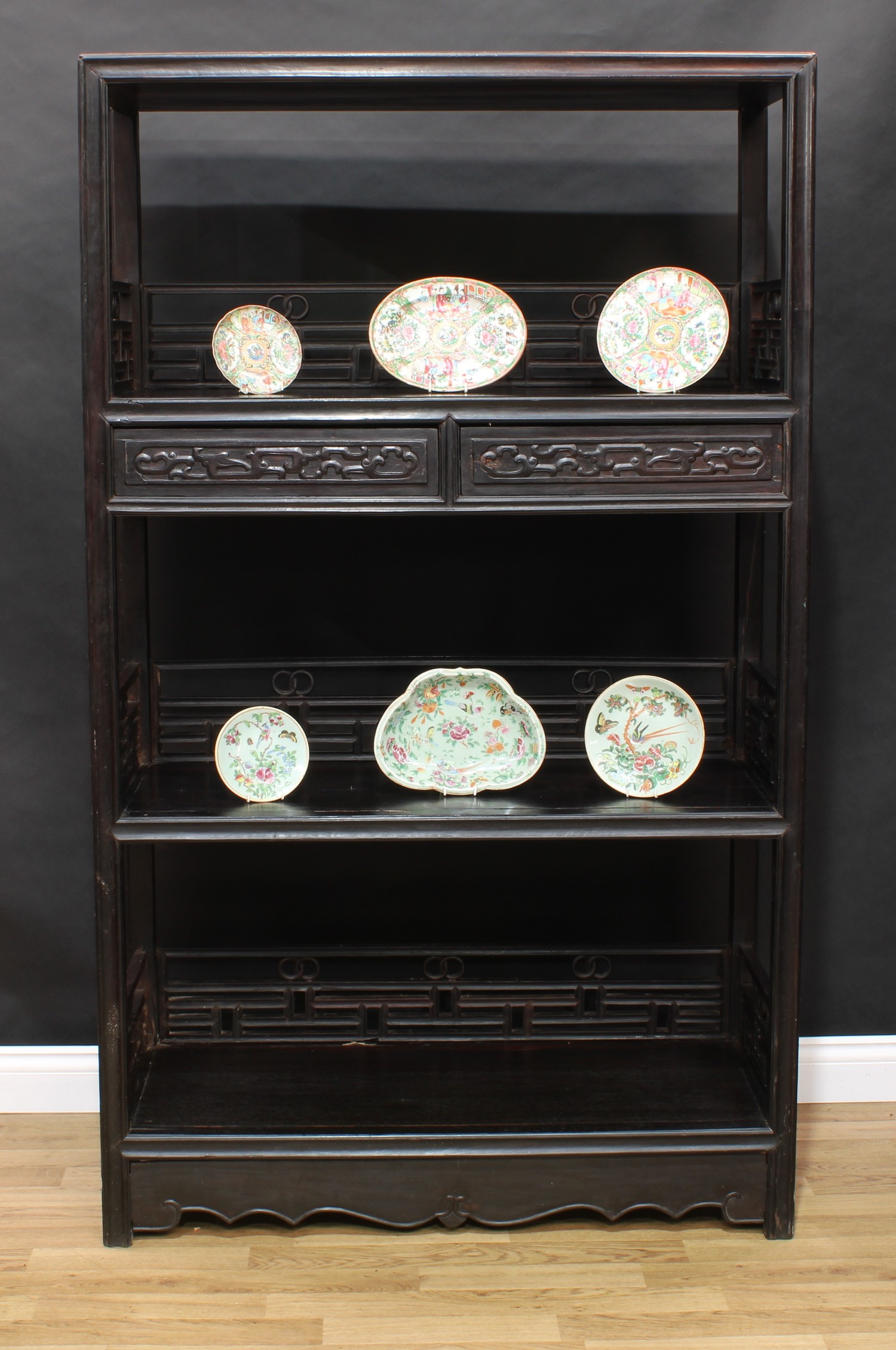 A Chinese hardwood open porcelain vitrine or display cabinet, flush rectangular top above three