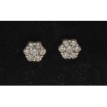 A pair of diamond cluster earrings each set with seven round brilliant cut diamonds, total est