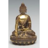 A Sinai-Tibetan gilt and brown patinated bronze or copper alloy Buddha, seated, lotus base, 11cm