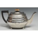A George III silver boat shaped teapot, bright-cut engraved with vacant wreath cartouches and