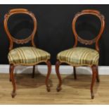 A pair of Victorian walnut balloon back side chairs, each cresting and mid rail carved with