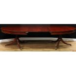 A Regency Revival mahogany twin-pillar extending dining table, oval top with two additional