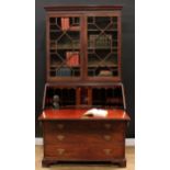A George III mahogany bureau bookcase, outswept meandering dentil cornice above a blind fretwork
