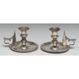 A pair of George IV silver circular chamber sticks, campana sconces, gadrooned borders, scroll