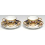 A pair of Lynton porcelain cabinet tea cups and stands, decorated in polychrome with butterflies,