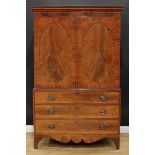A 19th century mahogany linen press, outswept cornice above a pair of rosewood crossbanded oval