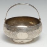 A Russian silver circular swing-handled bowl, engraved with leafy strapwork, flared foot ring, 10.