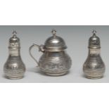 A Victorian silver three piece Signs of the Zodiac cruet, comprising mustard, salt and pepper, the