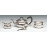 A silver three piece panelled boat shaped tea service, with strainer, ebonised button finial and