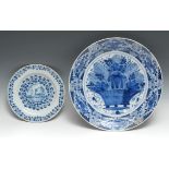 An 18th century Delft charger, painted in blue with band of flowers and scrolls, central panel
