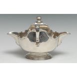 An 18th century silver double-lipped sauceboat, capped-double scroll handles, piecrust borders,