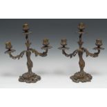 A pair of 19th century Rococo Revival bronze three-light candelabra, cast throughout with