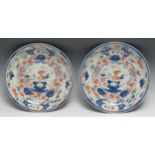 A pair of Japanese Imari circular dished plates, decorated with birds, holey rocks and foliage, 29cm