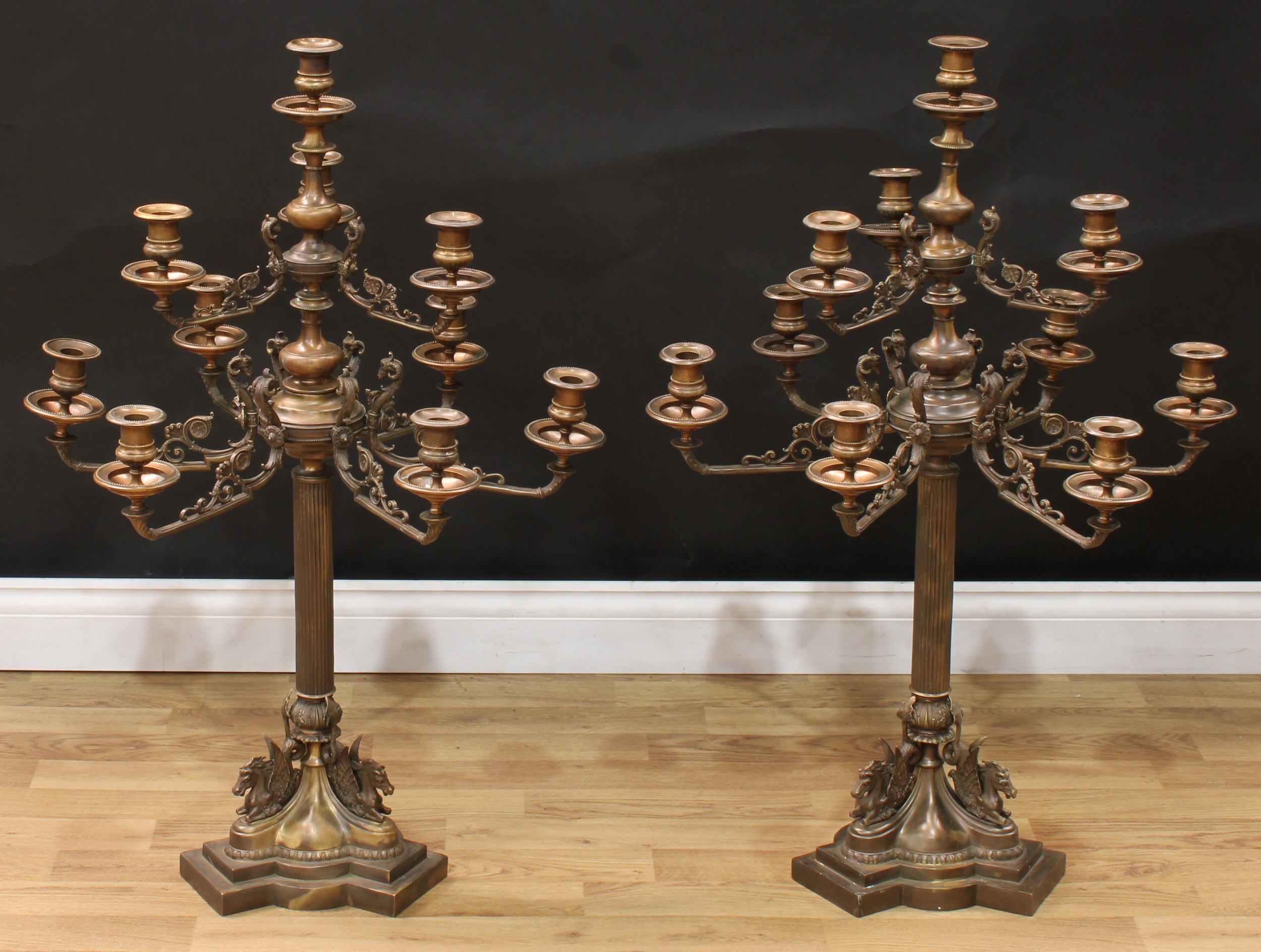 A pair of substantial Empire style bronze ten-light table candelabra, beaded campana sconces, the