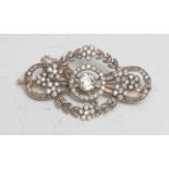 A gold and platinum diamond brooch, the central stone approx 0.50ct surrounded by a garland of