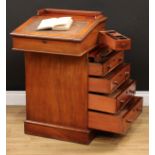 A Victorian mahogany Davenport desk, hinged sloping writing surface enclosing two small drawers, the