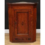 A George III corner cabinet, moulded cornice above a parquetry band of faux-crenellations and a