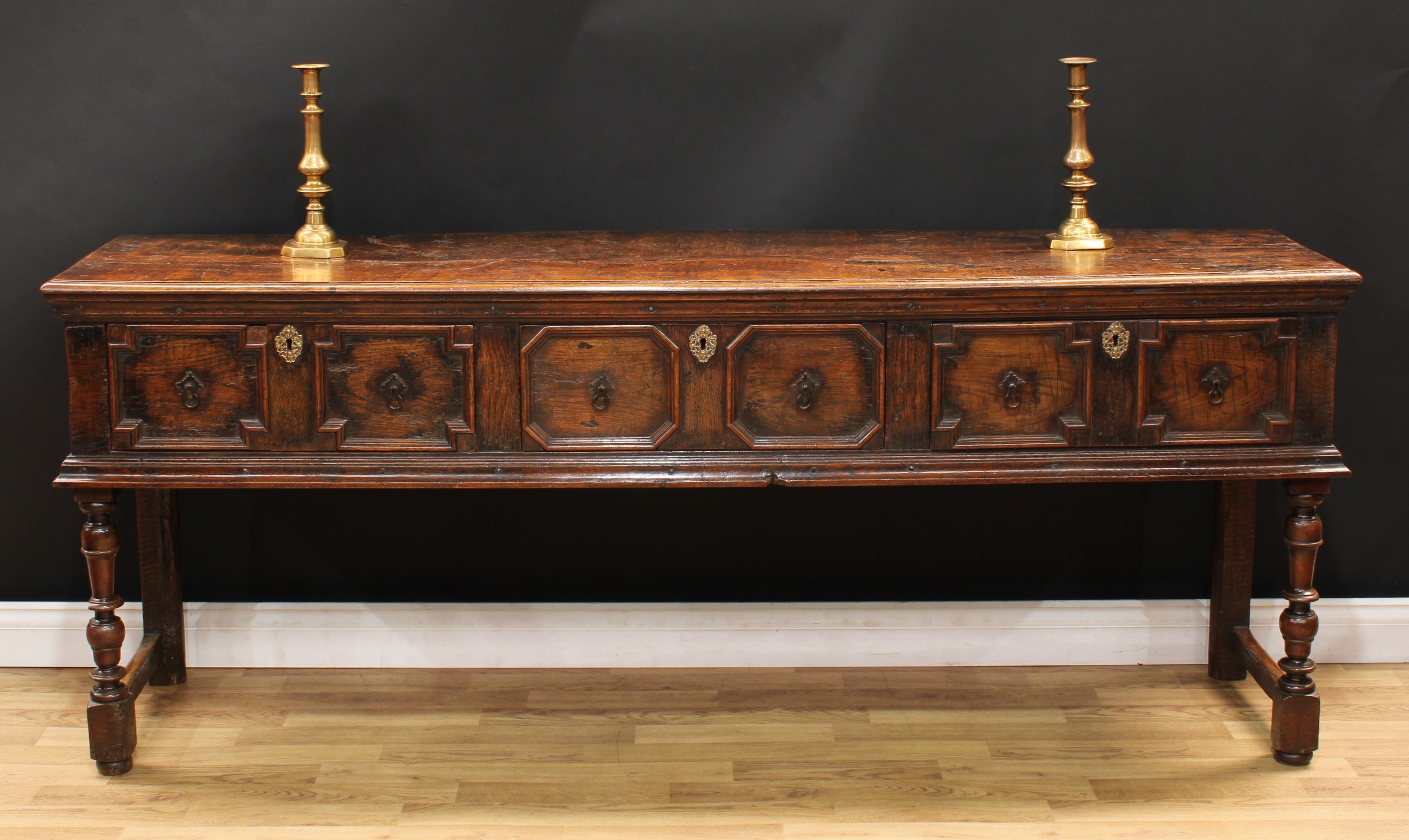 A Charles II design oak block front low dresser, oversailing plank top with moulded edge above three