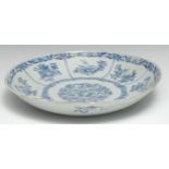 An 18th century Chinese circular dish, painted in tones of underglaze blue with a central reserve