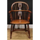 A 19th century yew and elm Windsor elbow chair, low hoop back, shaped and pierced splat, curved