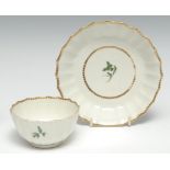 A Worcester faceted tea bowl and saucer, painted with green foliage, fretted square mark, c.1768-2