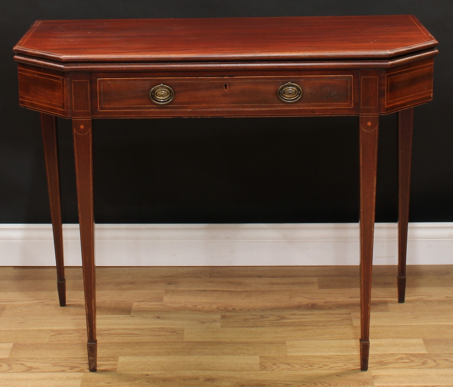 A George III mahogany tea table, canted rectangular top above a long frieze drawer, tapered square