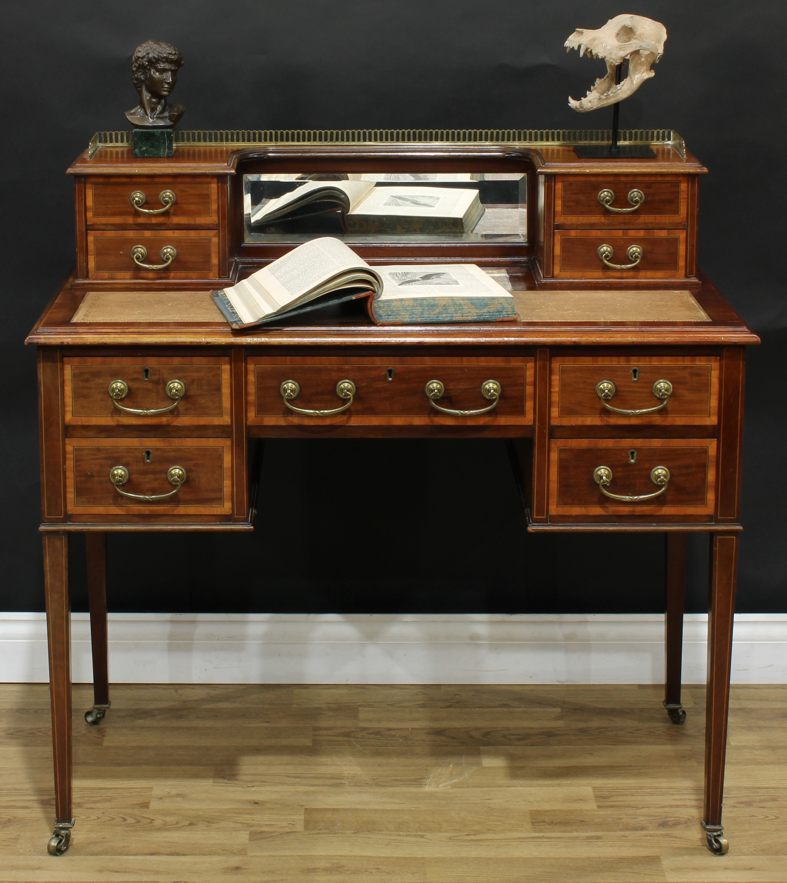 An Edwardian mahogany writing table, of bonheur du jour proportions, the inverted break-centre