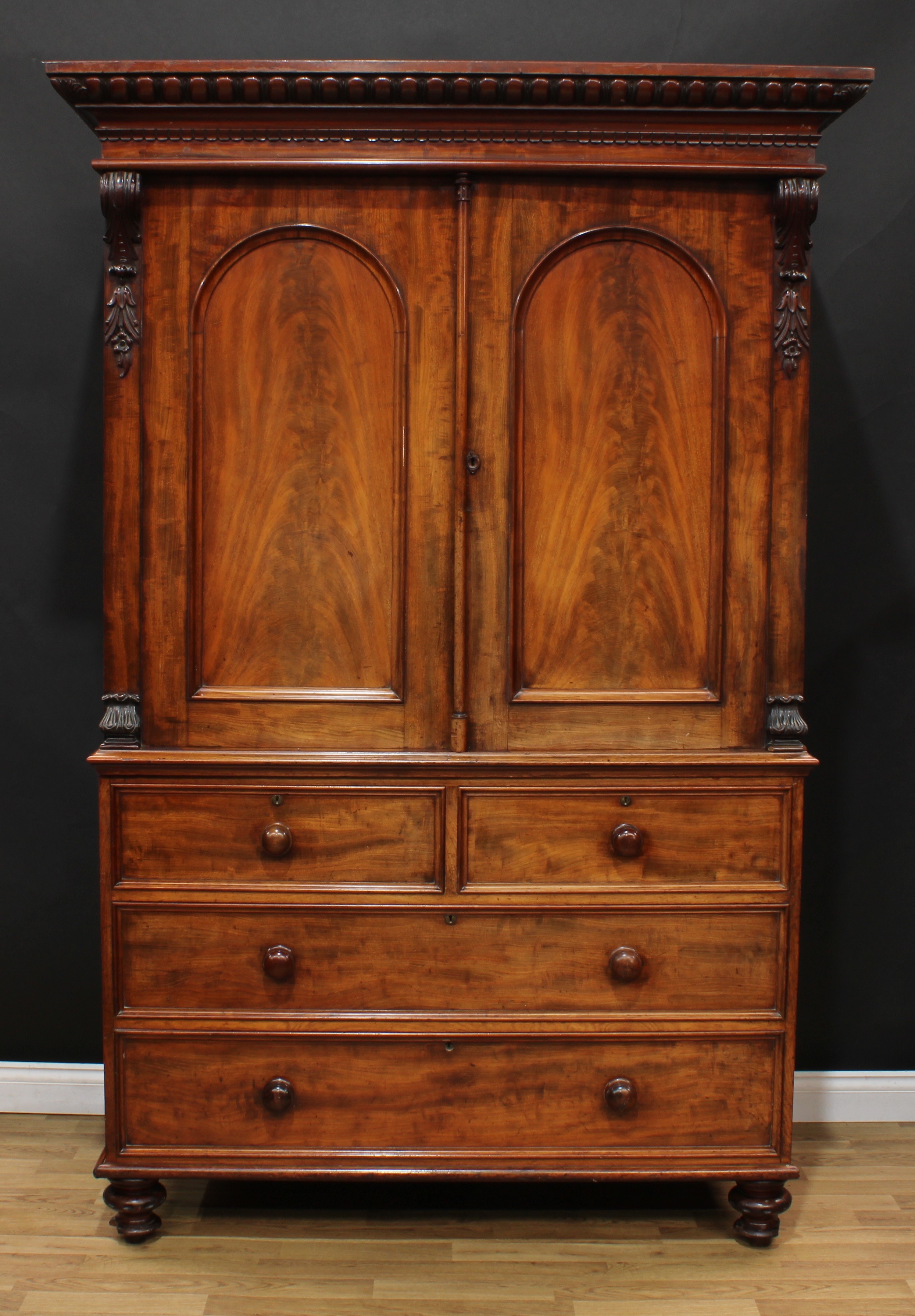 A William IV mahogany linen press, outswept egg-and-dart cornice above a pair of arched panel