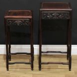 A graduated pair of Chinese hardwood occasional tables, panel tops, shaped friezes pierced and