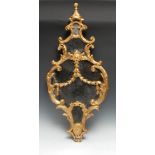 A mid-18th century giltwood and gesso cartouche shaped looking glass, knop finial, bordered and