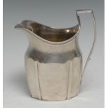 A George III silver commode shaped cream jug, bright-cut engraved with a shield shaped cartouche and