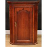 A George III mahogany crossbanded oak corner cabinet, moulded cornice above a raised and fielded