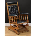 A 19th century giltwood rocking chair, deep-button stuffed-over upholstery, spindle galleries,