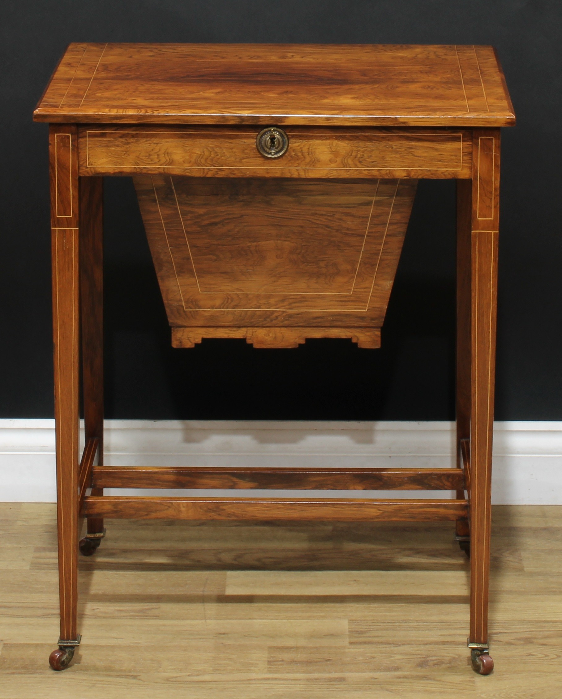 An Edwardian rosewood work table, hinged rectangular top enclosing a compartmented interior, the