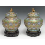 A pair of Chinese cloisonné enamel ogee-shaped vases and covers, the gilt ground decorated in relief