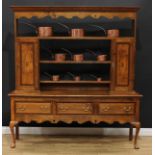 A George III style mahogany crossbanded oak dresser, moulded outswept cornice above a shaped and
