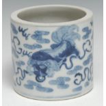 A Chinese porcelain cylinder brush pot, painted with shi-shi dogs and stylized scrolling clouds in