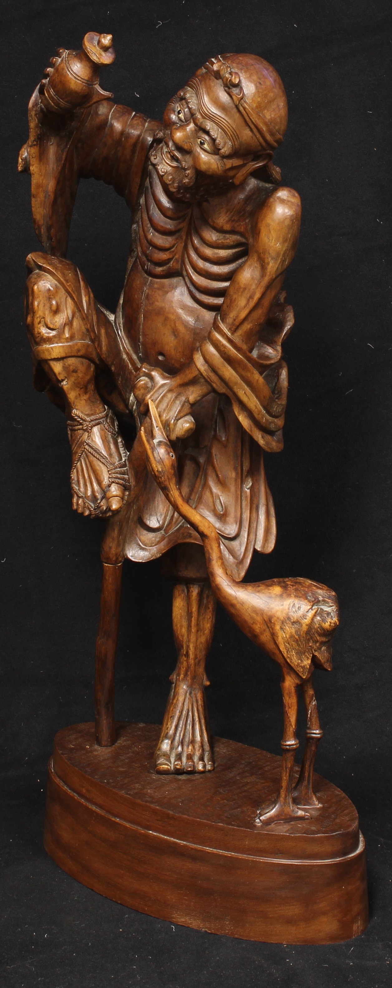 A large Japanese rootwood figure, carved as an emaciated elder beside a crane, oval base, 82cm high, - Image 3 of 4