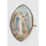 A George III navette shaped mourning brooch, the miniature painted with a muse beside a pedestal,