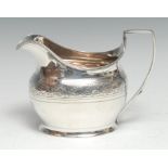 A George III silver boat shaped cream jug, bright-cut engraved with bands of stiff leaves and