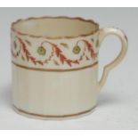 A Pinxton straight fluted coffee can, decorated in red and green with scrolling floral swags, gilt