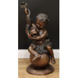 A 19th century style bronze, cast as a putto and dolphin, seated upon a sphere, stepped circular