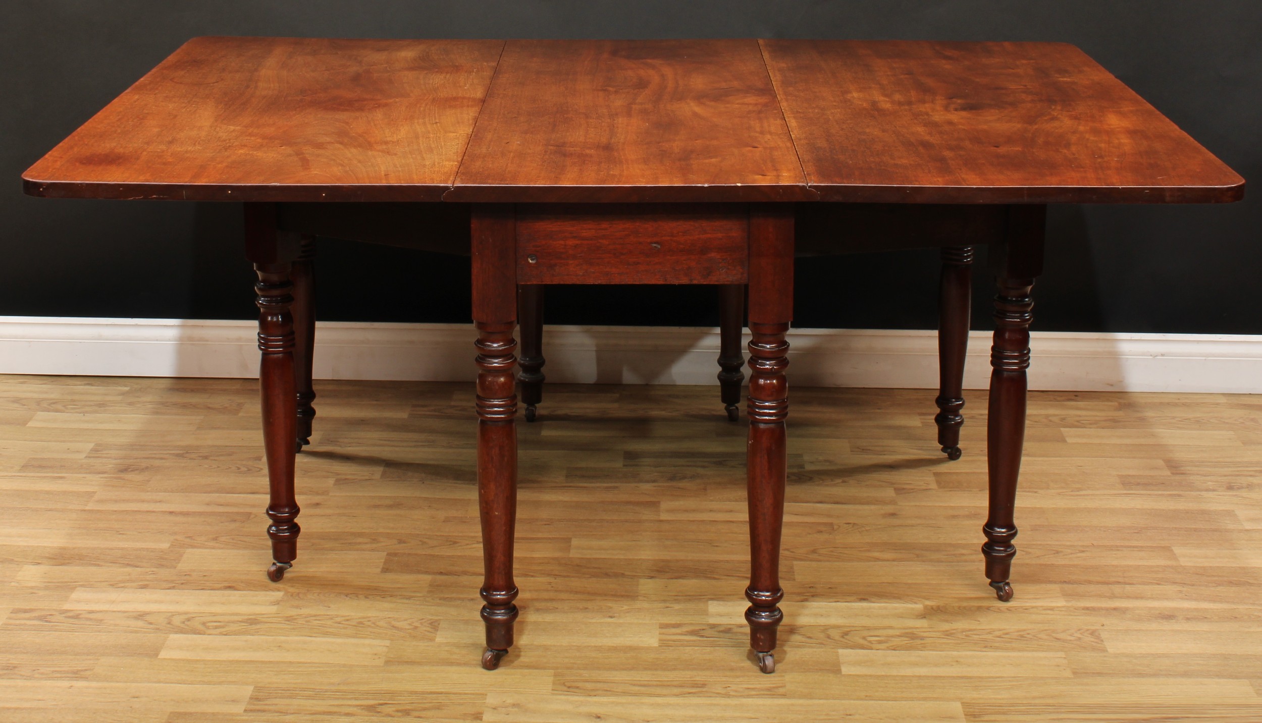 A 19th century mahogany gateleg dining table, rectangular top with fall leaves, ring-turned legs,